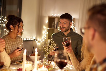 Image showing happy friends drinking red wine at christmas party