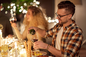 Image showing man pouring red wine to glass at dinner party