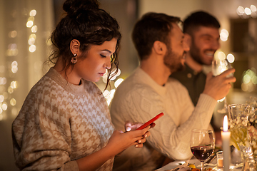 Image showing woman with smartphone at dinner party with friends