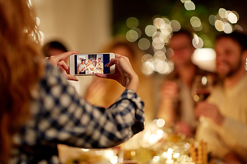 Image showing friends photographing at christmas dinner party