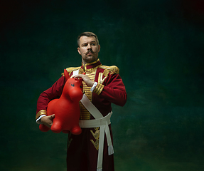 Image showing Young man as Nicholas II on dark green background. Retro style, comparison of eras concept.