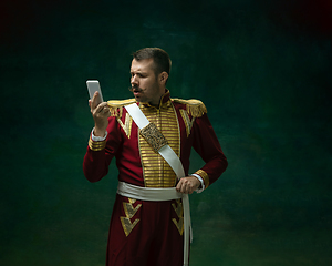 Image showing Young man as Nicholas II on dark green background. Retro style, comparison of eras concept.