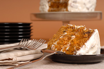 Image showing Carrot cake with forks, plates, and whole cake in background