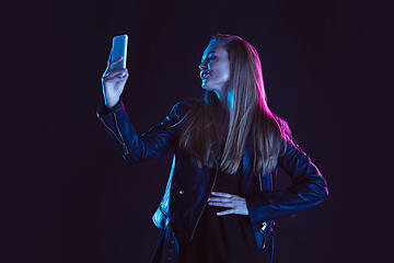 Image showing Portrait of young woman in neon light on dark backgound. The human emotions, black friday, cyber monday, purchases, sales, finance concept.