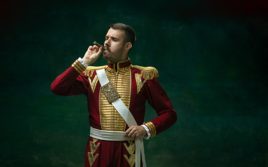 Image showing Young man as Nicholas II on dark green background. Retro style, comparison of eras concept.