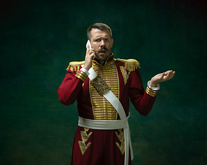 Image showing Young man as Nicholas II on dark green background. Retro style, comparison of eras concept.