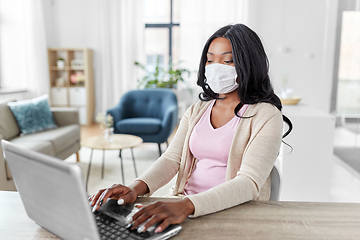 Image showing woman in mask with laptop working at home office