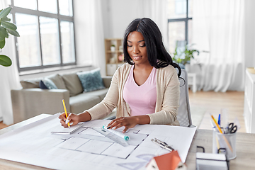 Image showing female architect with house model and blueprint