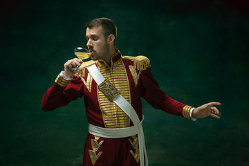 Image showing Young man as Nicholas II on dark green background. Retro style, comparison of eras concept.