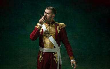 Image showing Young man as Nicholas II on dark green background. Retro style, comparison of eras concept.