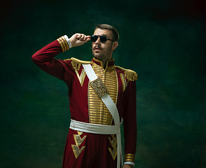 Image showing Young man as Nicholas II on dark green background. Retro style, comparison of eras concept.