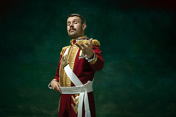 Image showing Young man as Nicholas II on dark green background. Retro style, comparison of eras concept.