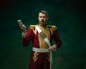 Image showing Young man as Nicholas II on dark green background. Retro style, comparison of eras concept.