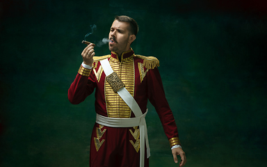 Image showing Young man as Nicholas II on dark green background. Retro style, comparison of eras concept.