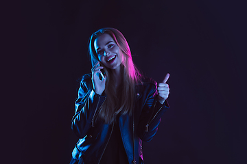 Image showing Portrait of young woman in neon light on dark backgound. The human emotions, black friday, cyber monday, purchases, sales, finance concept.