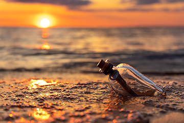 Image showing Message in the bottle against the Sun setting down