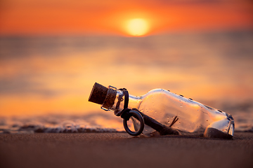 Image showing Message in the bottle against the Sun setting down