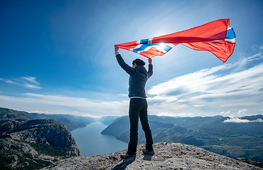 Image showing Woman with a waving flag of Norway on the background of nature