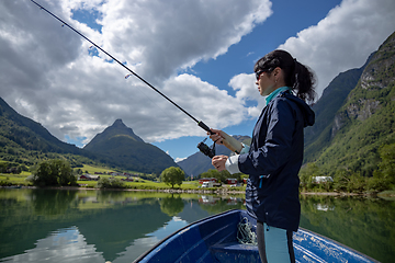 Image showing Woman fishing on Fishing rod spinning in Norway.