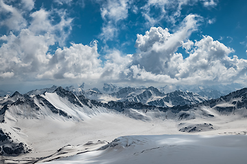 Image showing Mountain clouds over beautiful snow-capped peaks of mountains an