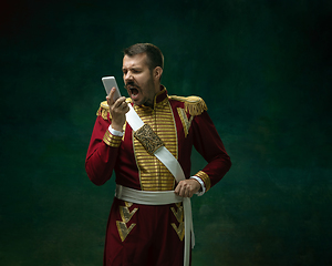 Image showing Young man as Nicholas II on dark green background. Retro style, comparison of eras concept.