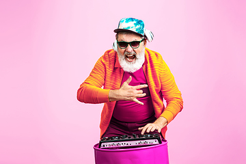 Image showing Senior hipster man wearing eyeglasses posing on pink background. Tech and joyful elderly lifestyle concept