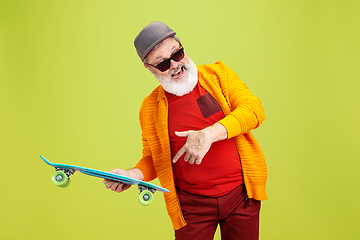 Image showing Senior hipster man wearing eyeglasses posing on green background. Tech and joyful elderly lifestyle concept