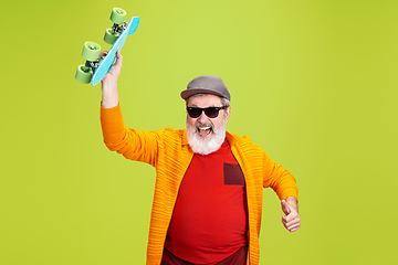 Image showing Senior hipster man wearing eyeglasses posing on green background. Tech and joyful elderly lifestyle concept