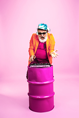 Image showing Senior hipster man wearing eyeglasses posing on pink background. Tech and joyful elderly lifestyle concept