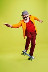 Image showing Senior hipster man wearing eyeglasses posing on green background. Tech and joyful elderly lifestyle concept