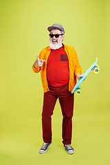 Image showing Senior hipster man wearing eyeglasses posing on green background. Tech and joyful elderly lifestyle concept