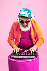 Image showing Senior hipster man wearing eyeglasses posing on pink background. Tech and joyful elderly lifestyle concept