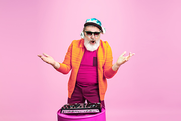 Image showing Senior hipster man wearing eyeglasses posing on pink background. Tech and joyful elderly lifestyle concept