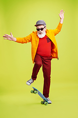 Image showing Senior hipster man wearing eyeglasses posing on green background. Tech and joyful elderly lifestyle concept