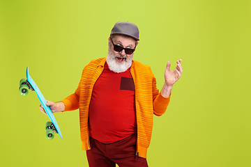 Image showing Senior hipster man wearing eyeglasses posing on green background. Tech and joyful elderly lifestyle concept