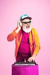 Image showing Senior hipster man wearing eyeglasses posing on pink background. Tech and joyful elderly lifestyle concept