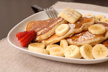 Image showing Banana pancakes with maple syrup and a fork