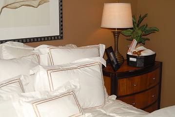 Image showing Bed with white bedspread and nightstand in the corner