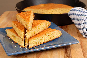 Image showing Stack of cornbread on a blue plate with skillet in background