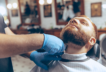 Image showing Man getting hair cut at the barbershop wearing mask during coronavirus pandemic