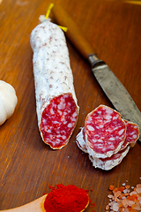 Image showing traditional Italian salame cured sausage sliced on a wood board