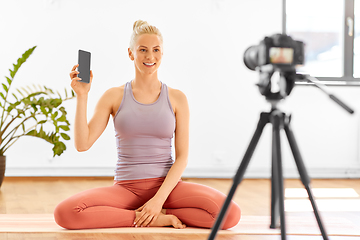 Image showing woman with phone streaming for yoga blog at home