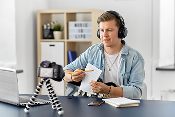 Image showing man or blogger with camera, music book and guitar