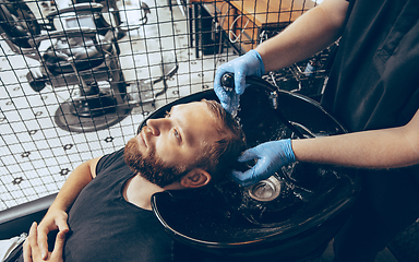 Image showing Man getting hair cut at the barbershop wearing mask during coronavirus pandemic