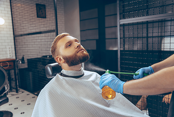 Image showing Man getting hair cut at the barbershop wearing mask during coronavirus pandemic