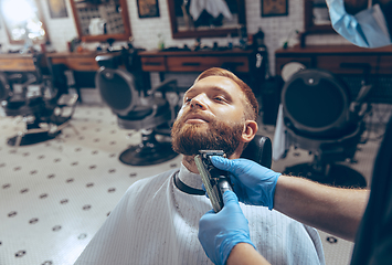 Image showing Man getting hair cut at the barbershop wearing mask during coronavirus pandemic