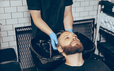 Image showing Man getting hair cut at the barbershop wearing mask during coronavirus pandemic