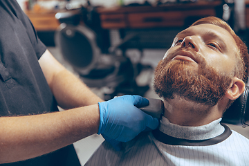 Image showing Man getting hair cut at the barbershop wearing mask during coronavirus pandemic