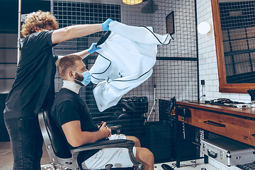 Image showing Man getting hair cut at the barbershop wearing mask during coron