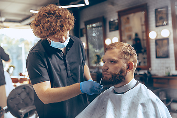 Image showing Man getting hair cut at the barbershop wearing mask during coronavirus pandemic